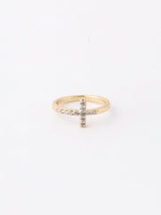 Gold ring with a cross design on a white background
