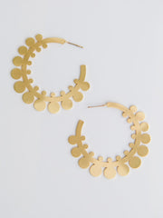 Gold hoop earrings with floral design on a light gray background