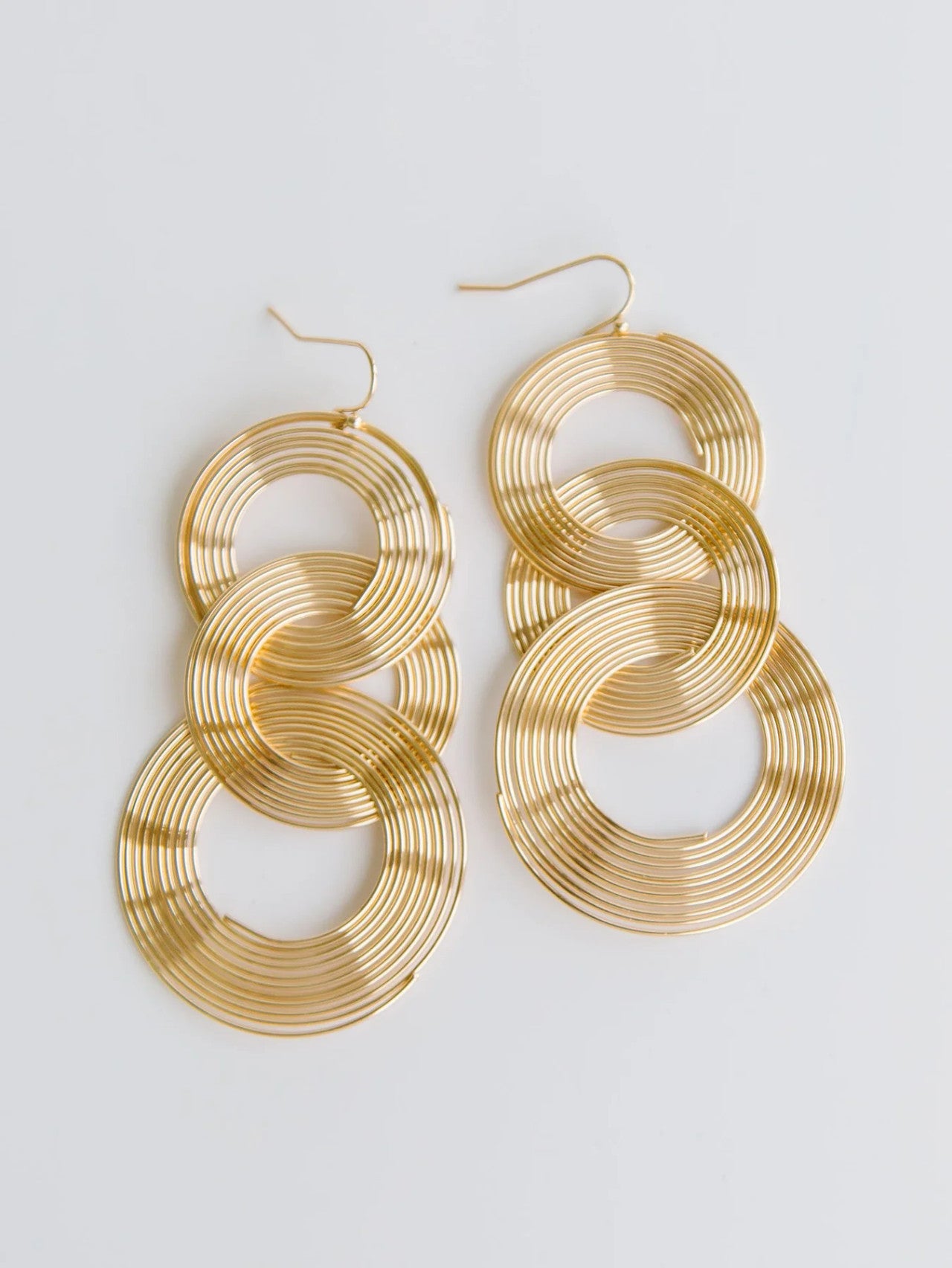Gold hoop earrings on a light gray background