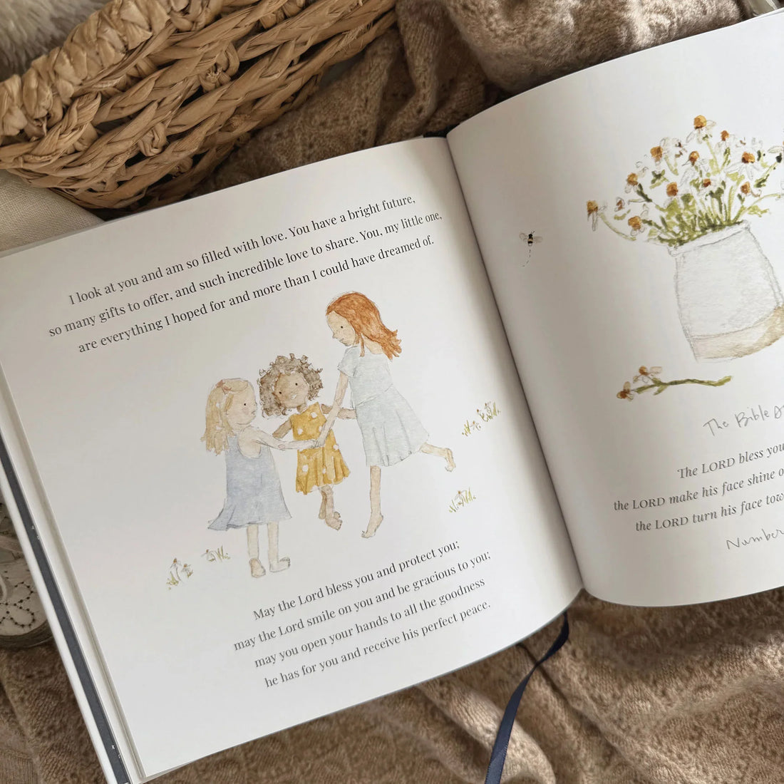 Open book with illustrations of children and flowers on a textured surface