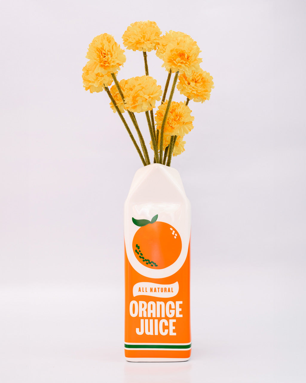 Vase shaped like an orange juice bottle with yellow flowers on a white background