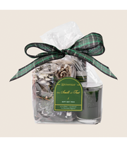 Seasonal - Smell of tree Gift Set showing candle, spray and potpourri that make up the set.  Tied in a clear bag with a green plaid bow. 