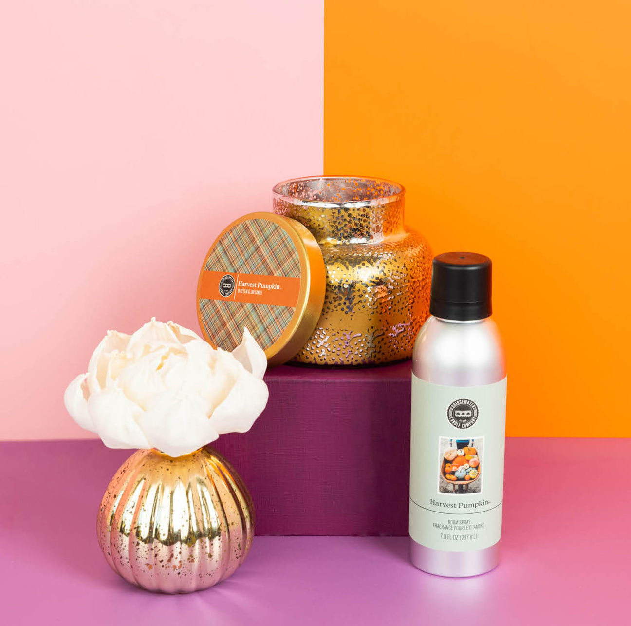 Seasonal - Room Spray - Harvest Pumpkin scent - silver bottle with gray label.  Product is sitting on a pink, purple and orange background with coordinating products
