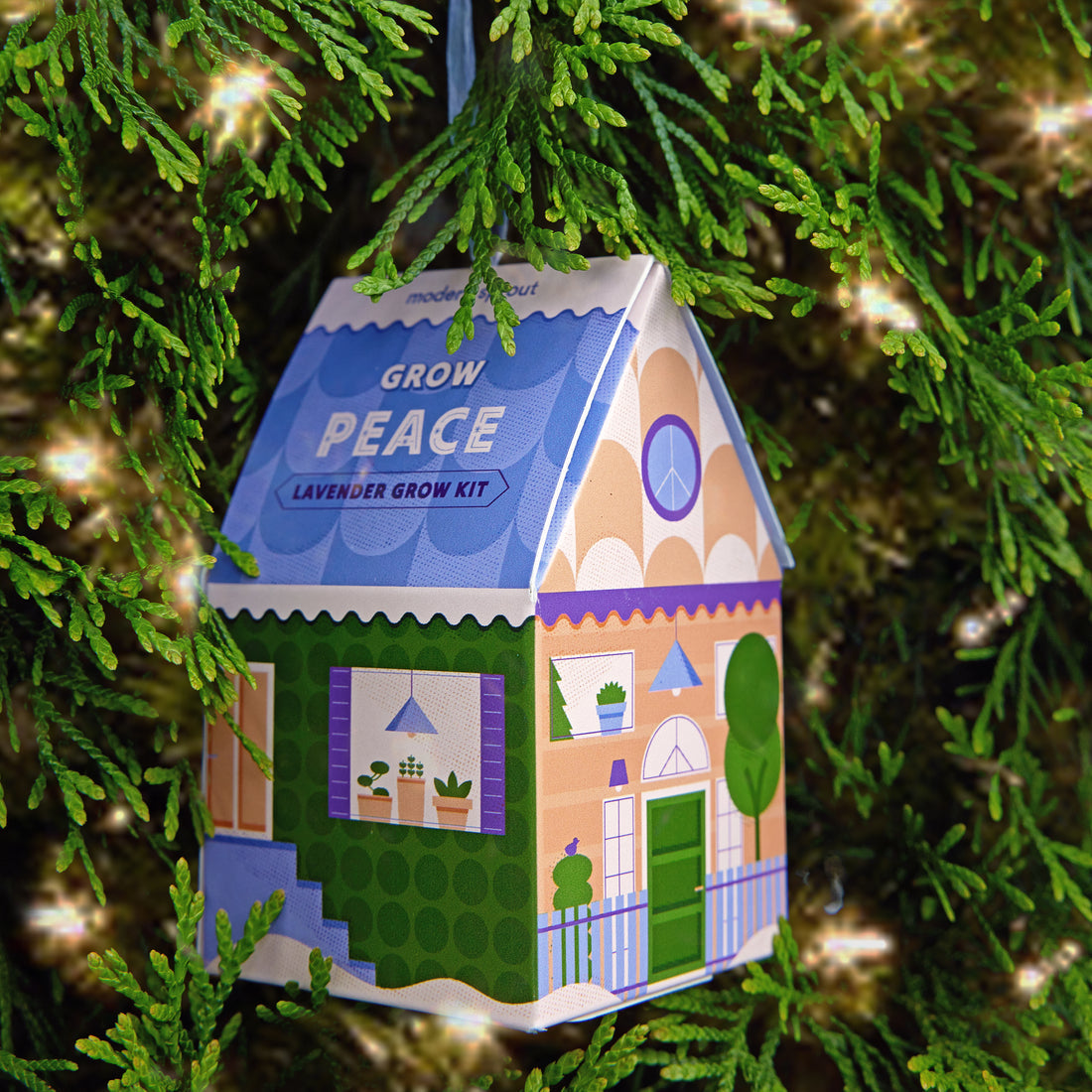 Seasonal - cardboard Ornament - Home Grown - Grow Peace - Lavender box in house shape hanging on a Christmas tree with white lights 