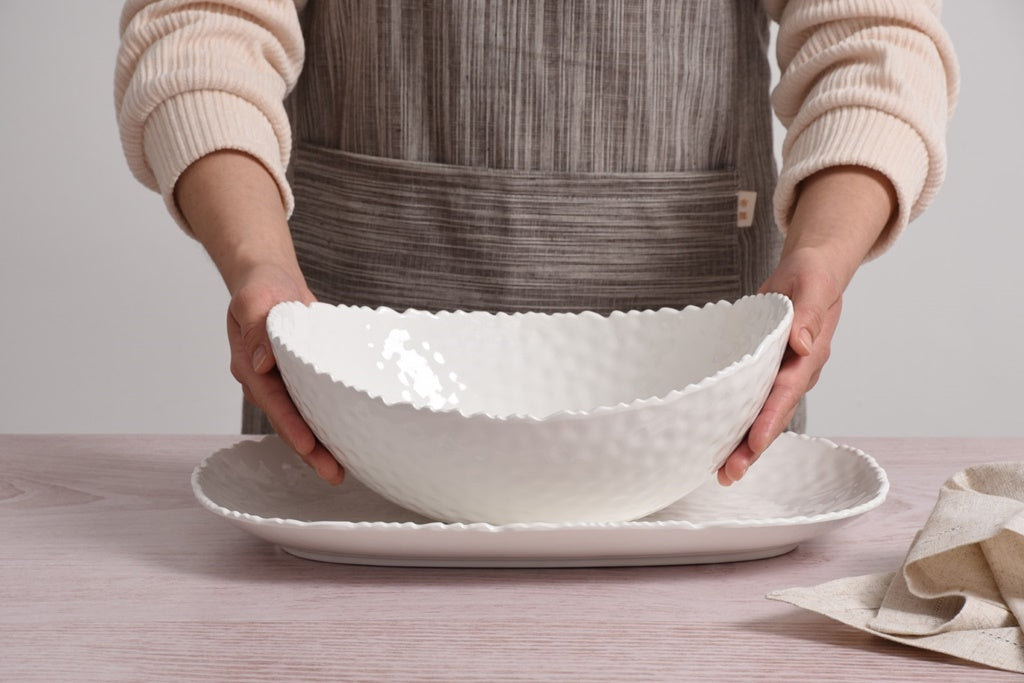 Person holding a Pampa Bay Large Oval Bowl Melamine White on a wooden table