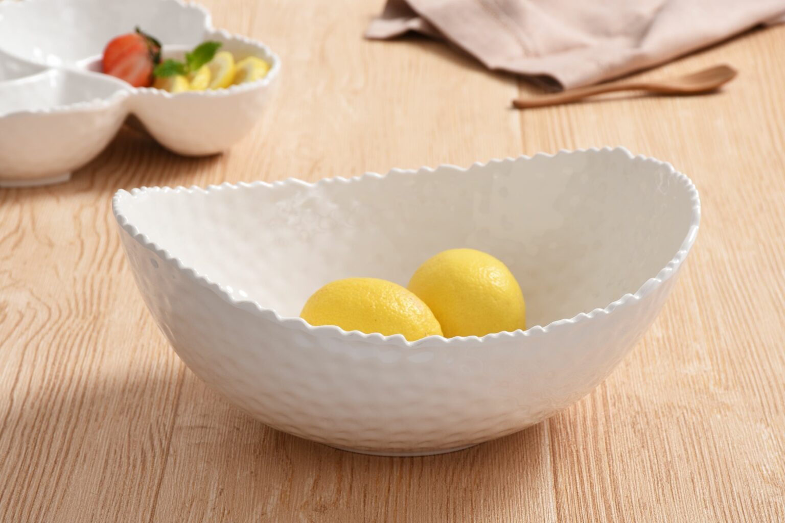  Large Oval Bowl Melamine White Pampa Bay with scalloped edge containing lemons on a wooden surface.