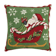 Decorative pillow with a festive design of Santa Claus in a sleigh, surrounded by snowflakes on a green background.