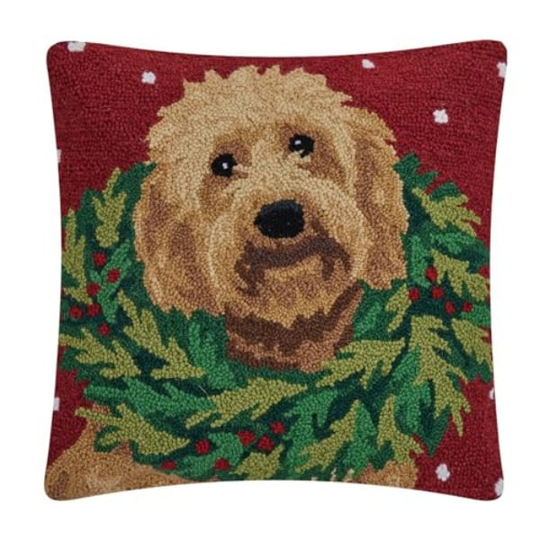 Decorative pillow with a dog and holly design on a red background