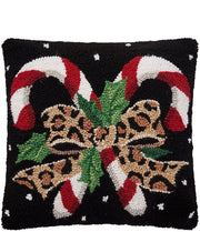 Decorative pillow with candy canes, leopard print bows, and Christmas elements on a black background.