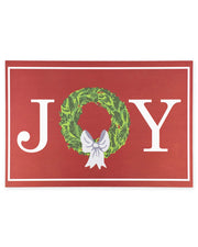 Red placemat with 'JOY' text, green wreath, and white bow on a white background