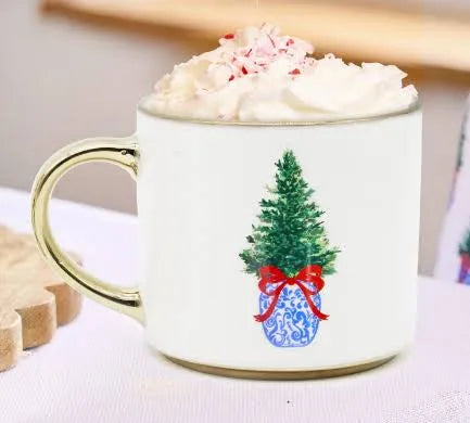 Mug with Christmas tree design and whipped cream on a white surface
