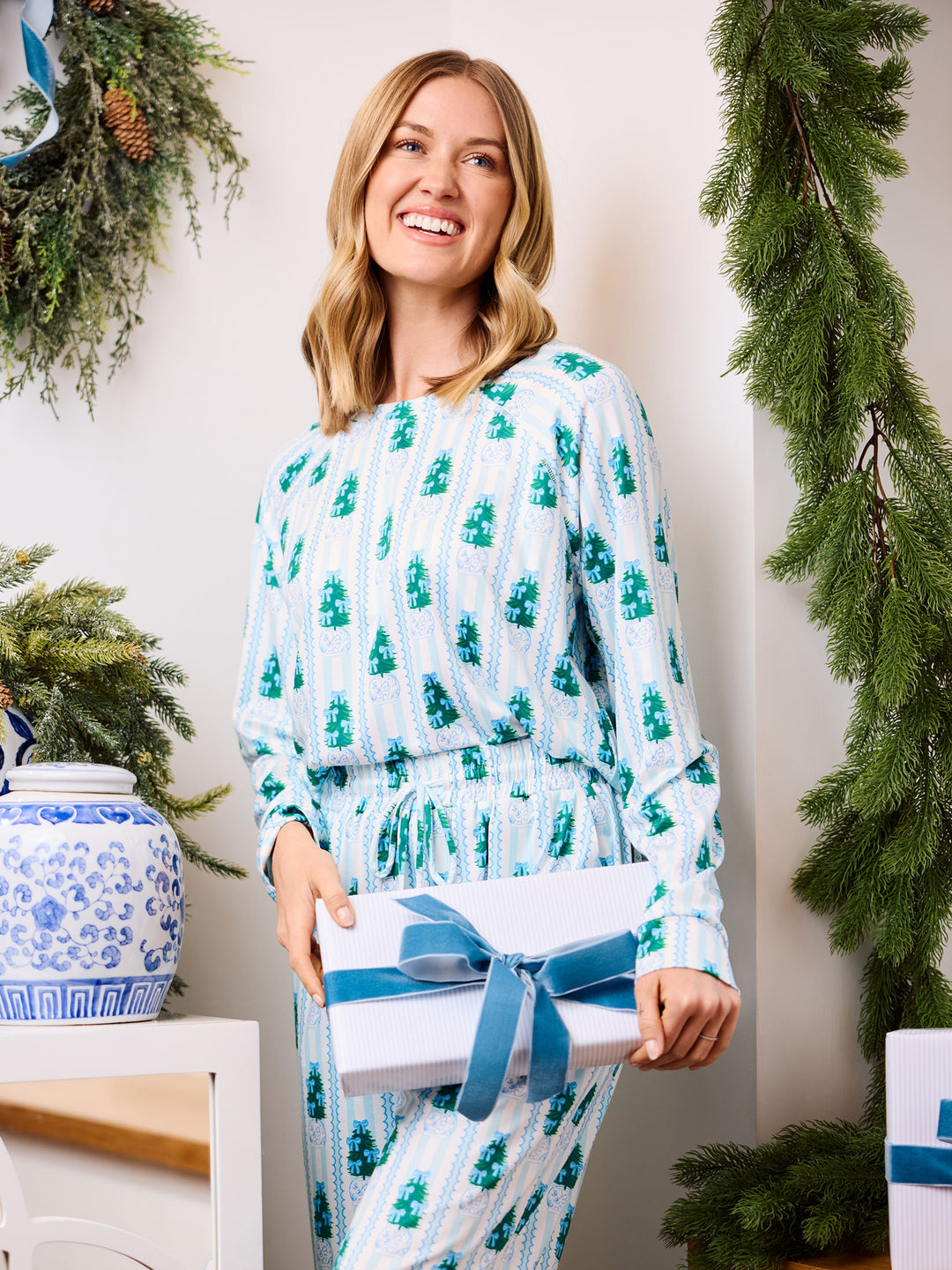 Woman in Christmas pjs holding gift 