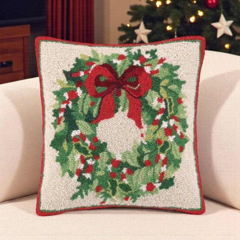 Decorative pillow with a Christmas wreath design on a couch.