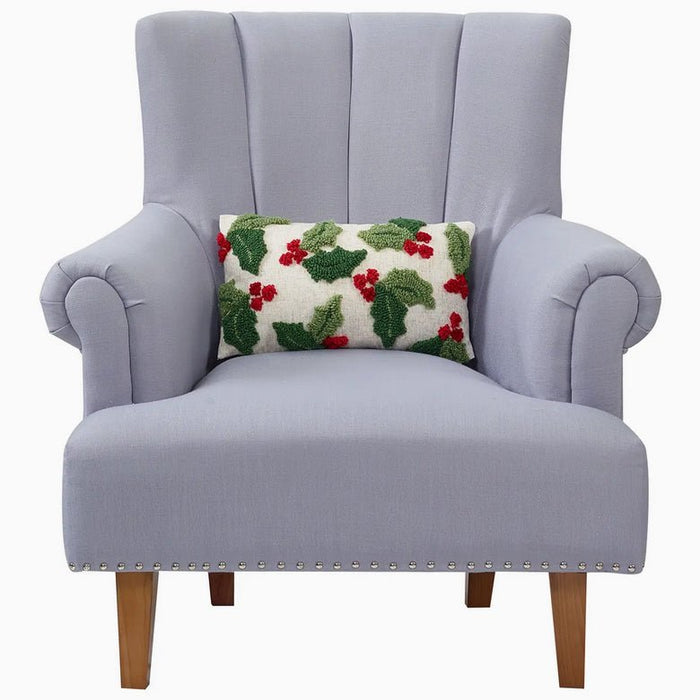 Gray armchair with a decorative pillow featuring holly pattern on a white background