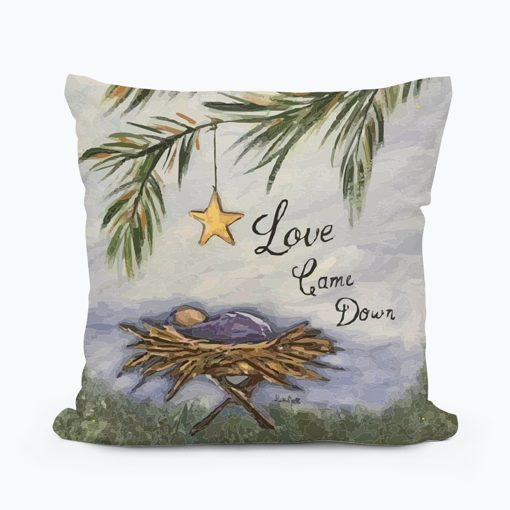 Decorative pillow with a nest, star, and text 'Love Came Down' on a white background