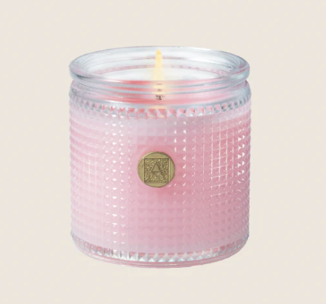 Peony Petals Candle 6 oz Pink candle in a textured glass jar with a visible brand logo on a beige background