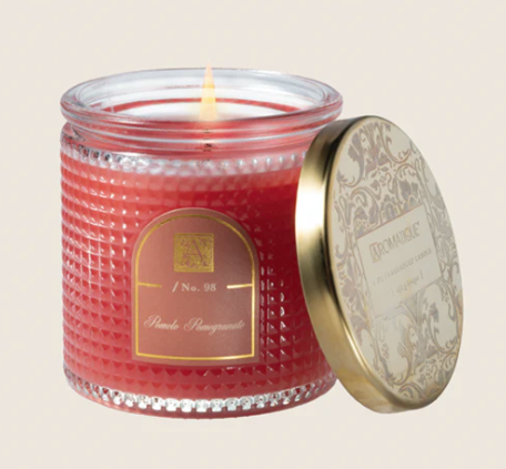 Aromatique Red candle in a glass jar with a decorative lid on a beige background
