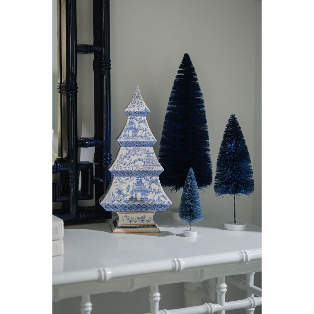 Decorative blue and white tree with other trees on a white surface