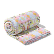 Floral-patterned quilt rolled up on a white background
