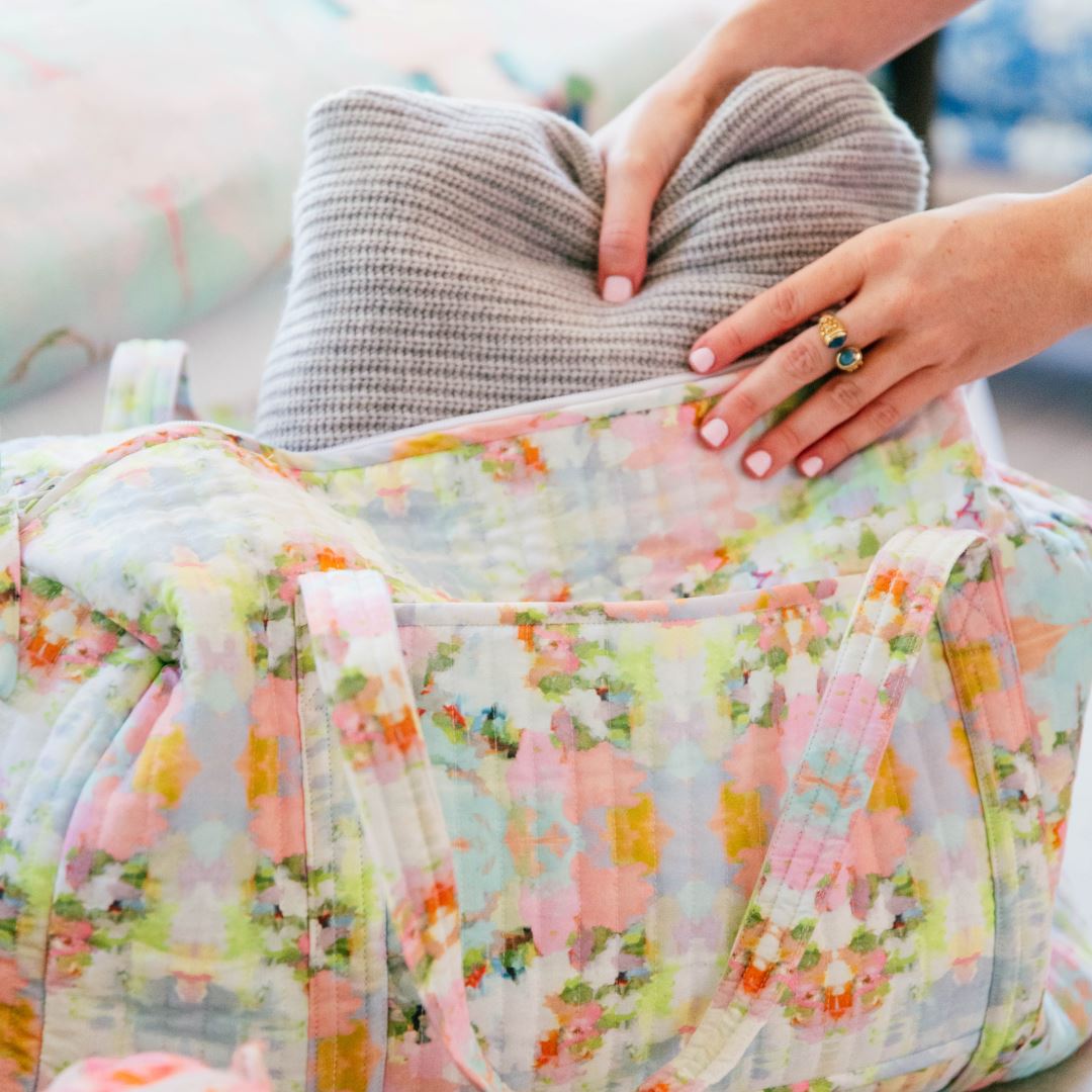 Person holding a floral-patterned fabric with a blurred background