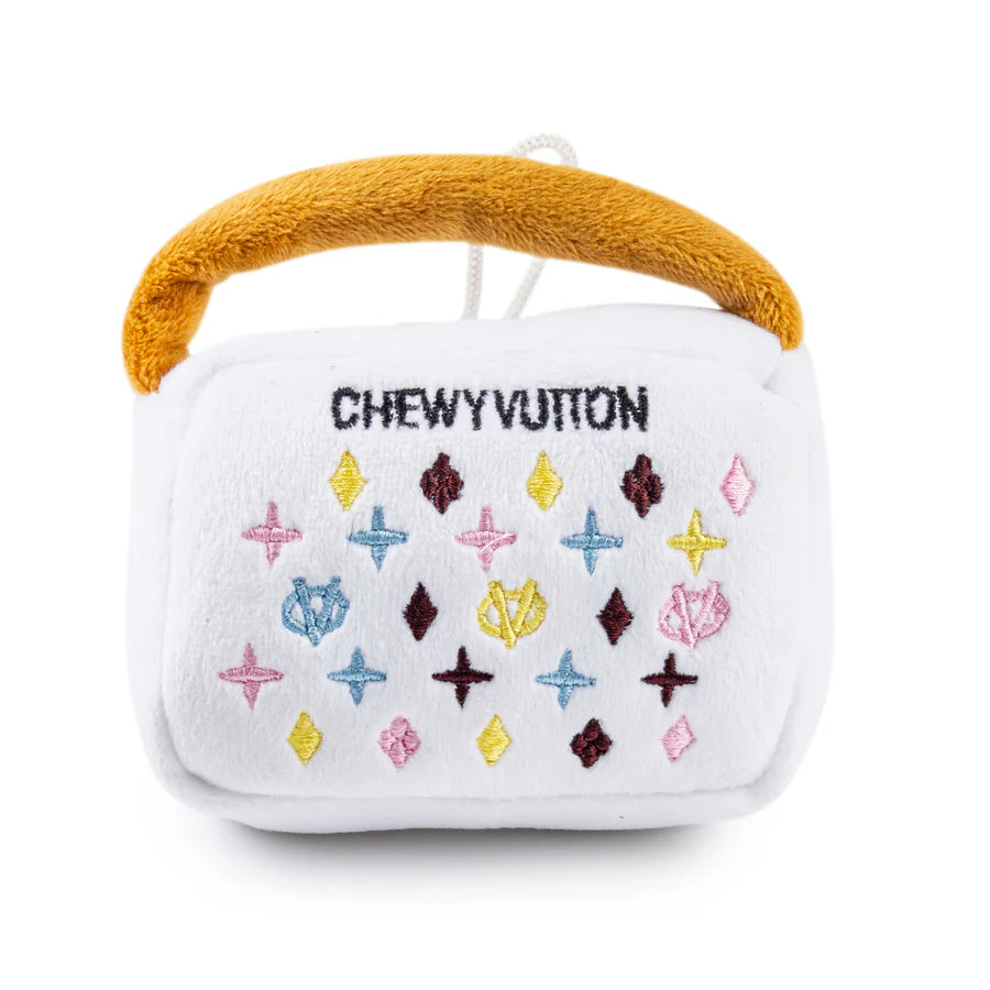 White plush toy with colorful patterns and a mustard yellow handle on a white background