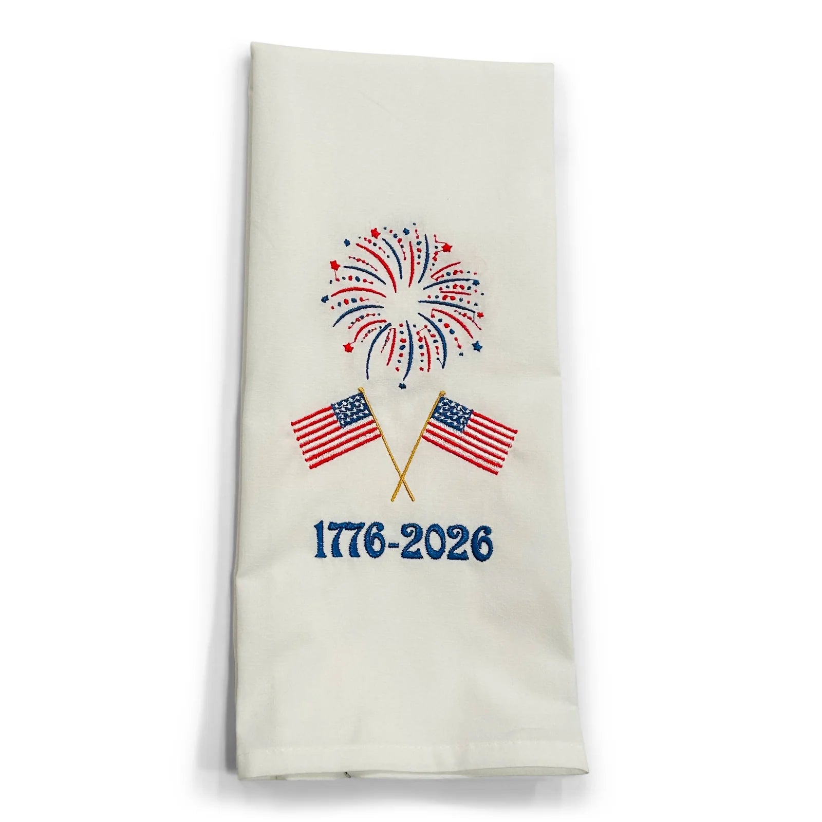 Decorative towel with American flags, fireworks, and '1776-2026' text on a white background