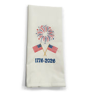 Decorative towel with American flags, fireworks, and '1776-2026' text on a white background