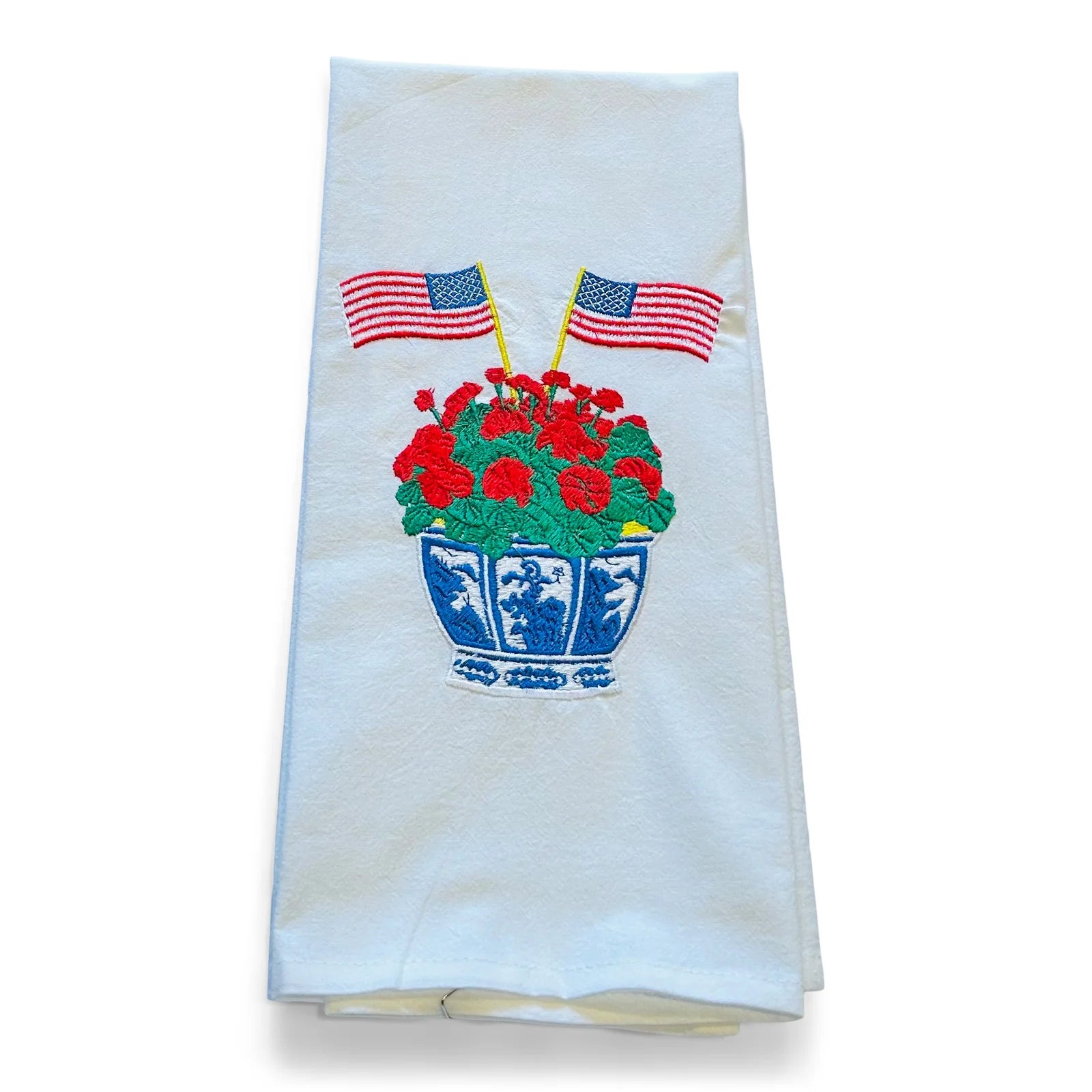 Embroidered towel with a floral design and American flags on a white background