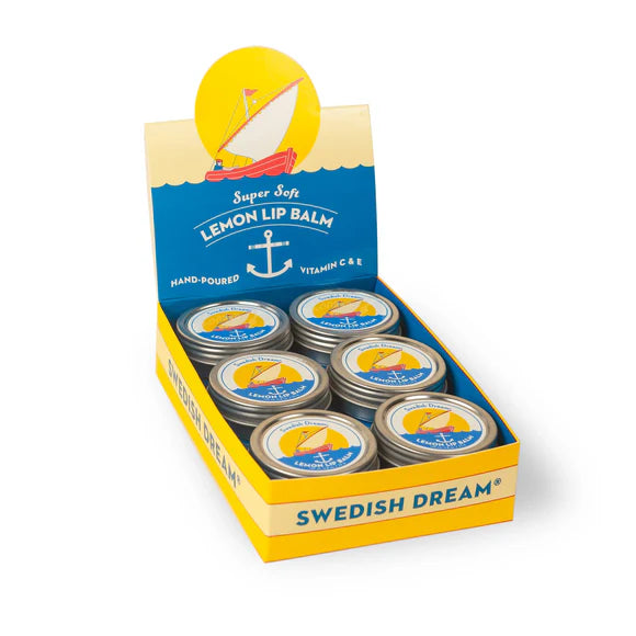 Display box of Swedish Dream lemon lip balm with a sailboat design on a white background