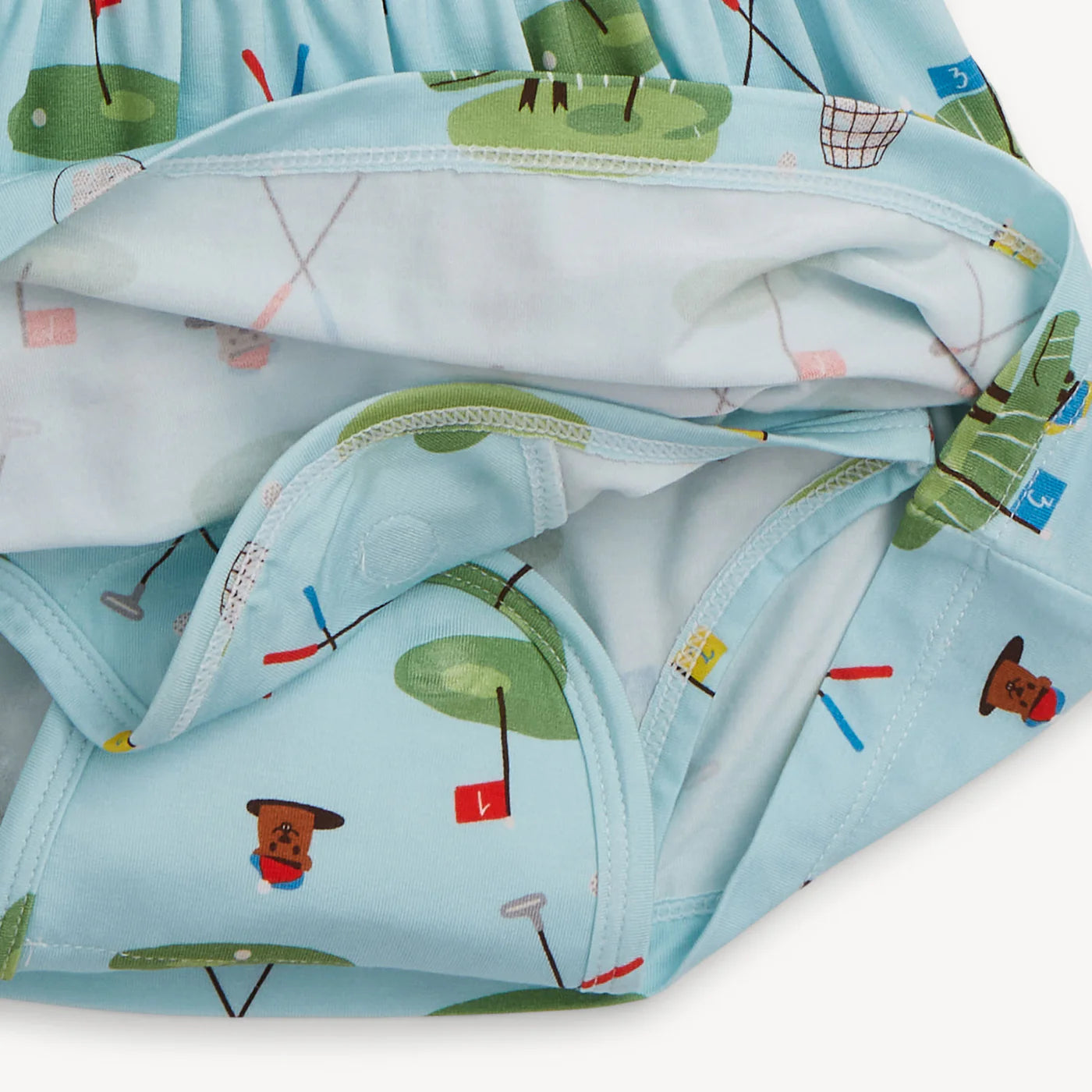 Children's light blue sleeveless dress with golf pattern with golf clubs, flags and greens showing the diaper cover under the skirt on a white background
