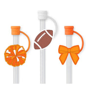 Two clear straws with orange ends and decorative attachments on a white background Swig