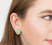 Close-up of a woman wearing Susan Shaw stud gold earrings with a turquoise stone.