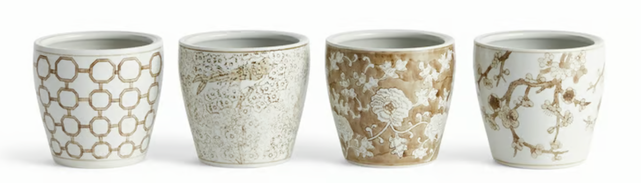 Four white ceramic cachepots with taupe and white floral and geometric patterns, arranged in a row against a white background.