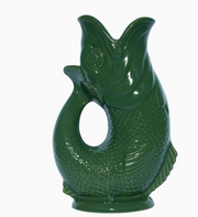 The Gluggle Jug Factory Brand  glossy dark green ceramic fish-shaped pitcher with a textured scale pattern and a central loop hole, shown on a plain white background.