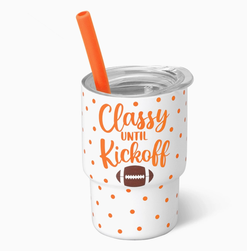 Shot glass tumbler with clear lid and orange straw with Classy Until Kickoff written in orange on front and brown football on white background
