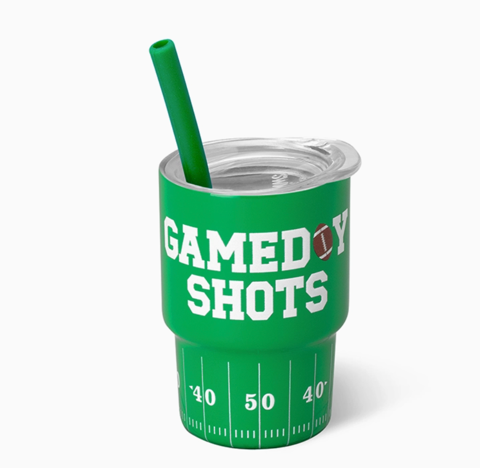 A green insulated shot glass with a clear lid and matching green straw, printed with the words 'GAMEDAY SHOTS' and a football-field yard-line graphic on a light gray background.