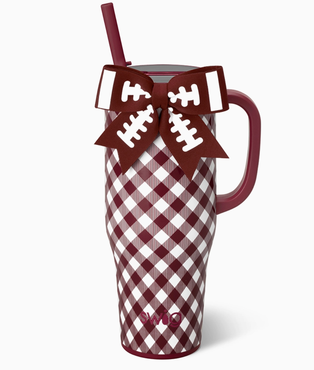 A tall insulated tumbler with a garnet and white gingham pattern, a maroon handle, and a matching ganet straw. A football-shaped ribbon bow with white laces is tied around the upper portion of the tumbler.