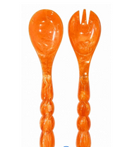 Laura Park Designs orange resin salad server set of one spoon and one fork on white background