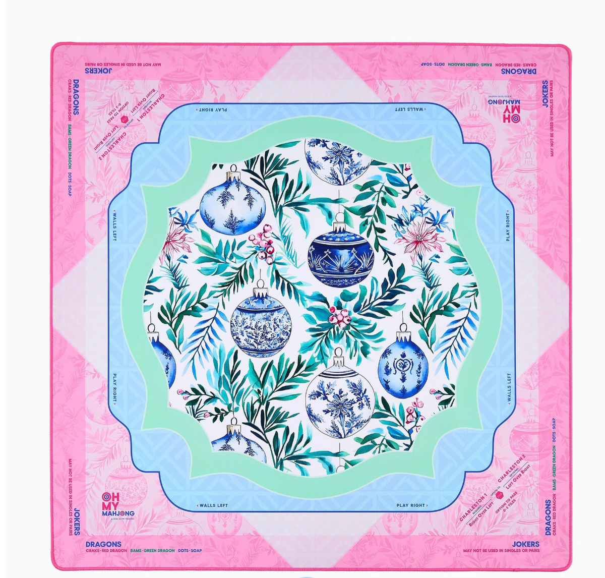 Oh My Mahjong Merriment mat with blue-and-white Christmas ornaments, winter greenery, and scalloped mint and blue borders inside a pink edge.