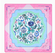Oh My Mahjong Merriment mat with blue-and-white Christmas ornaments, winter greenery, and scalloped mint and blue borders inside a pink edge.