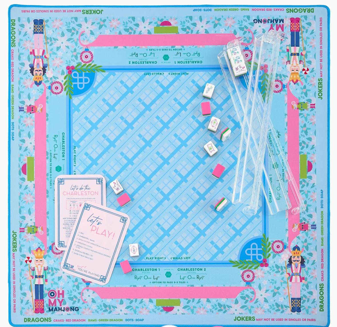 Oh My Mahjong Sugarplum blue-and-pink nutcracker mat with clear racks, scattered tiles, and pink reference cards