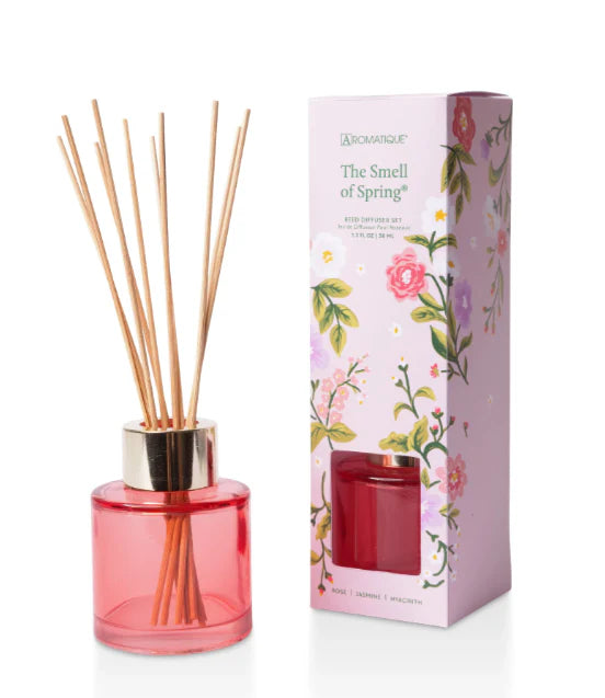 Red diffuser with wooden sticks and floral packaging on a white background