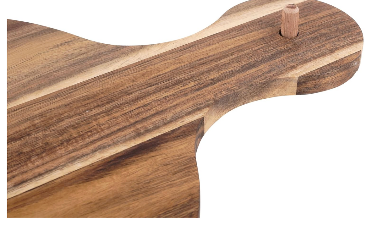 Wooden cutting board with a handle on a white background with a peg to add a decorative topper