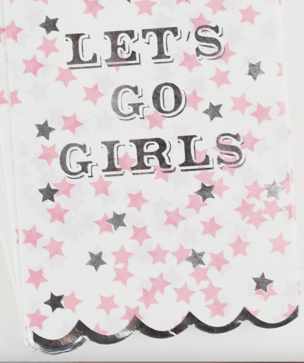 Guest size paper napkinswith 'Let's Go Girls' text silver scalloped edge and star patterns on a white background