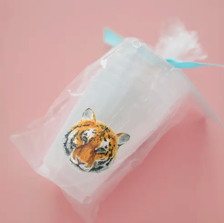 Tiger face on frosted cup in a set wrapped in clear bag with turquoise ribbon with a pink background