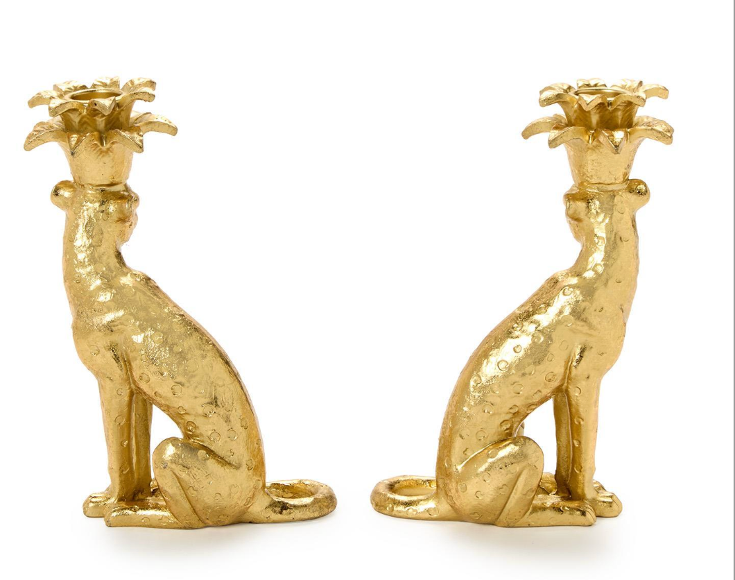 Two gold leopard-shaped candle holders on a white background