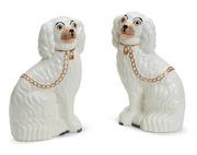 Two Staffordshire white dogs facing each other with collar and gold chain draped on their backs. 