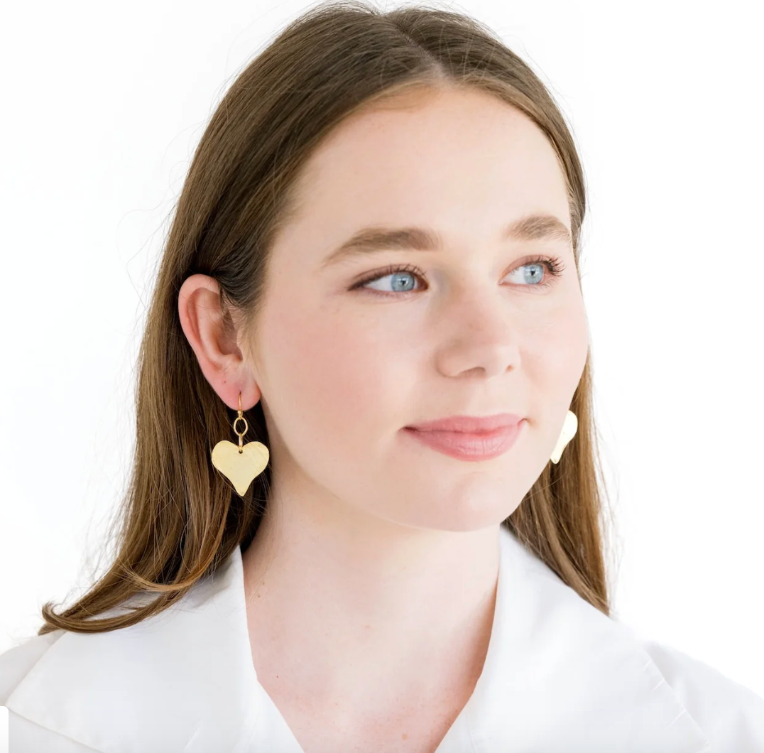 Woman wearing Susuan Shaw Heart shaped earrings on white background