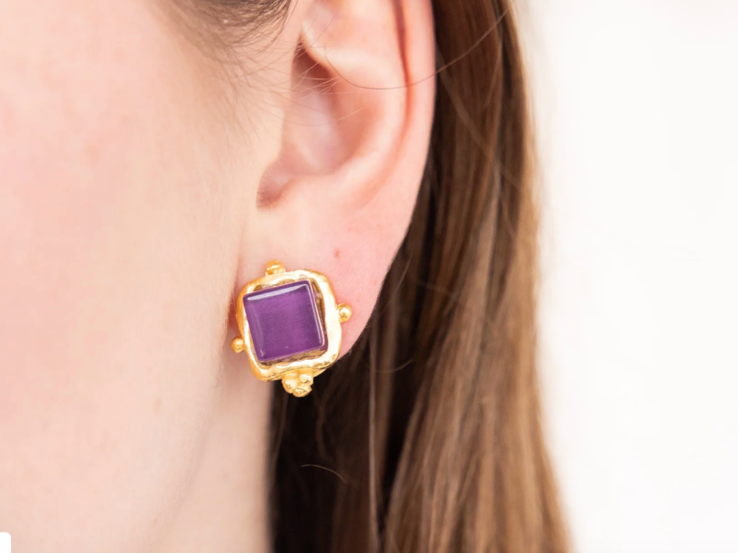 Susan Shaw brand Gold earring with purple gemstone worn by a person