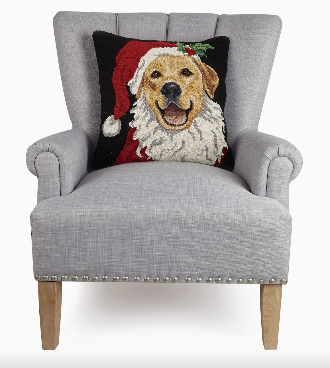 Peking Handicrafts brand decorative Christmas pillow with a Golden retriever dog wearing a Santa hat on a navy pillow on a Gray armchair on a white background